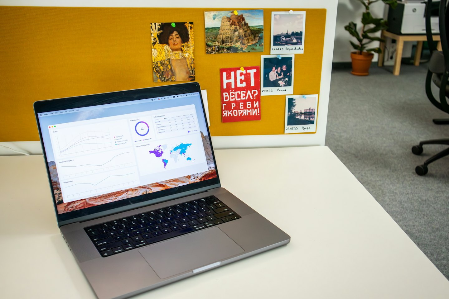 Zilveren laptop met een data-analyse dashboard op een wit bureau.