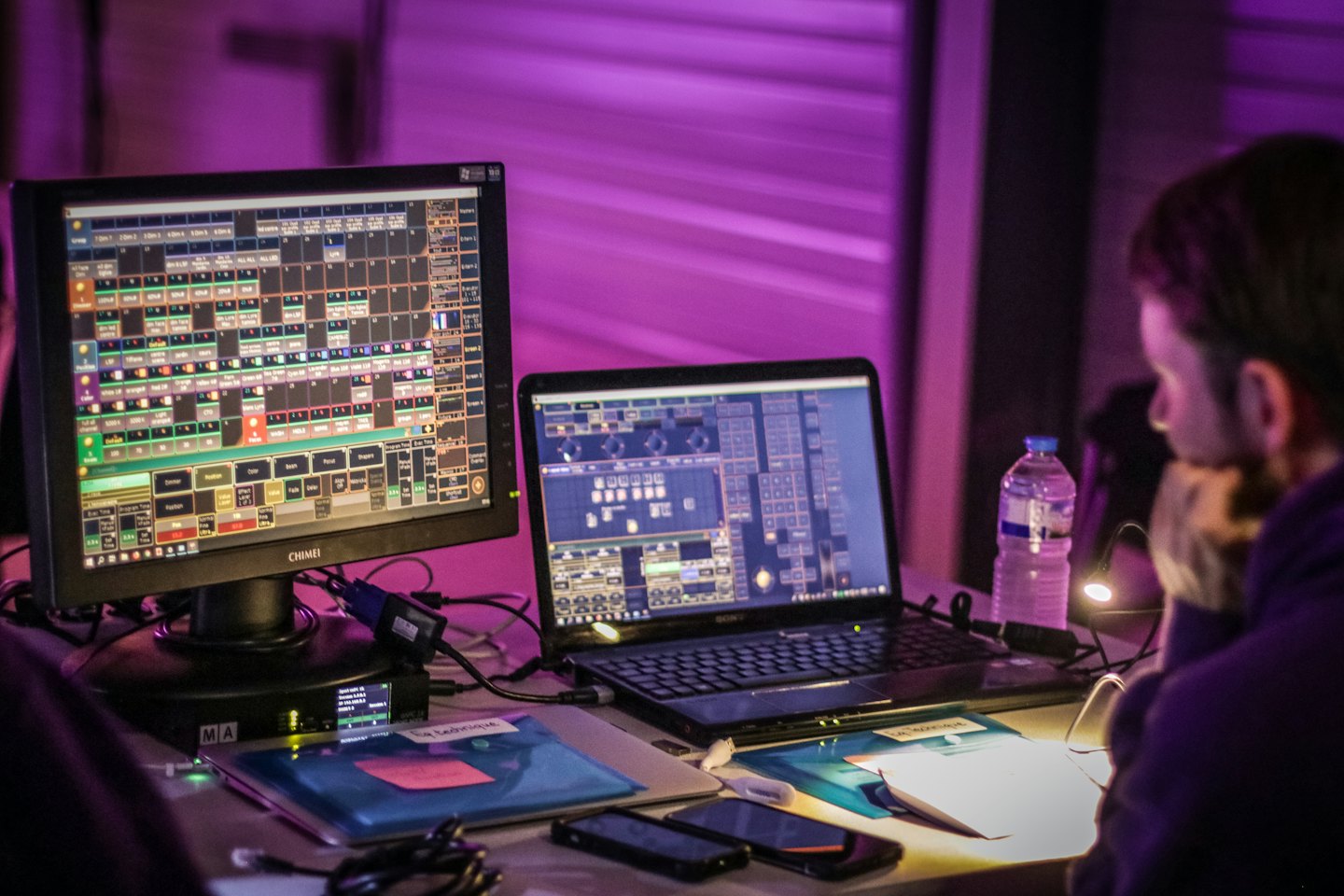 Man die podiumverlichting bedient met twee computerschermen.